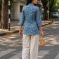 Woman wearing Aster Blue Cotton Top styled with beige linen pants, showcasing breathable cotton fabric and floral print design