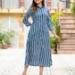 Woman wearing a blue and white striped dress standing outdoors.
