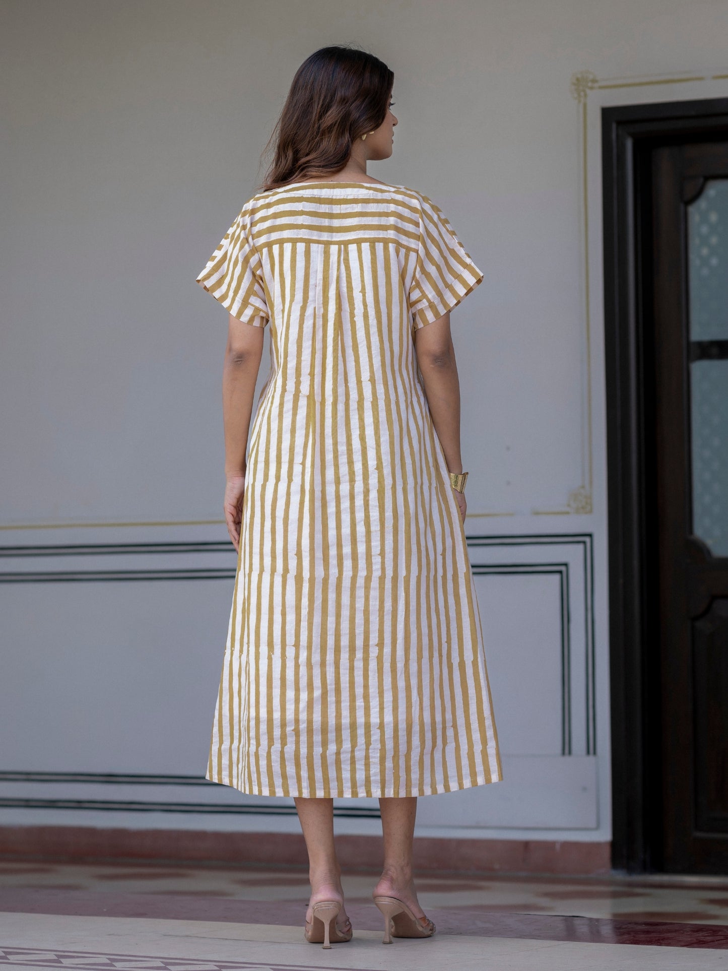Woman wearing Darzaania The Weekend Dress, a pure cotton handblock stripe midi dress, viewed from the back